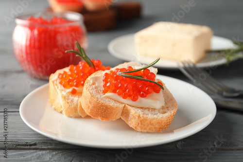 Delicious sandwiches with red caviar on plate