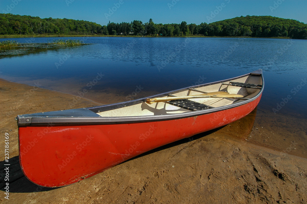 Large red canoe onshore of lake Large red canoe onshore of lake