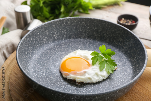 Tasty fried egg with liquid yolk in pan