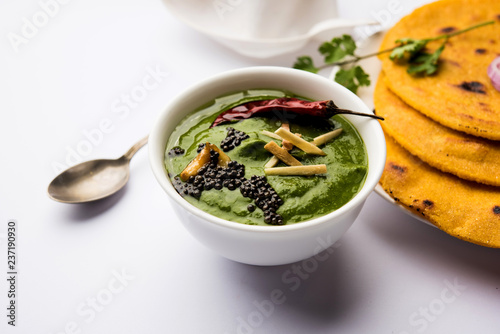 Makki di roti with sarson ka saag, popular punjabi main course recipe in winters made using corn breads mustard leaves curry. served over moody background. selective focus photo