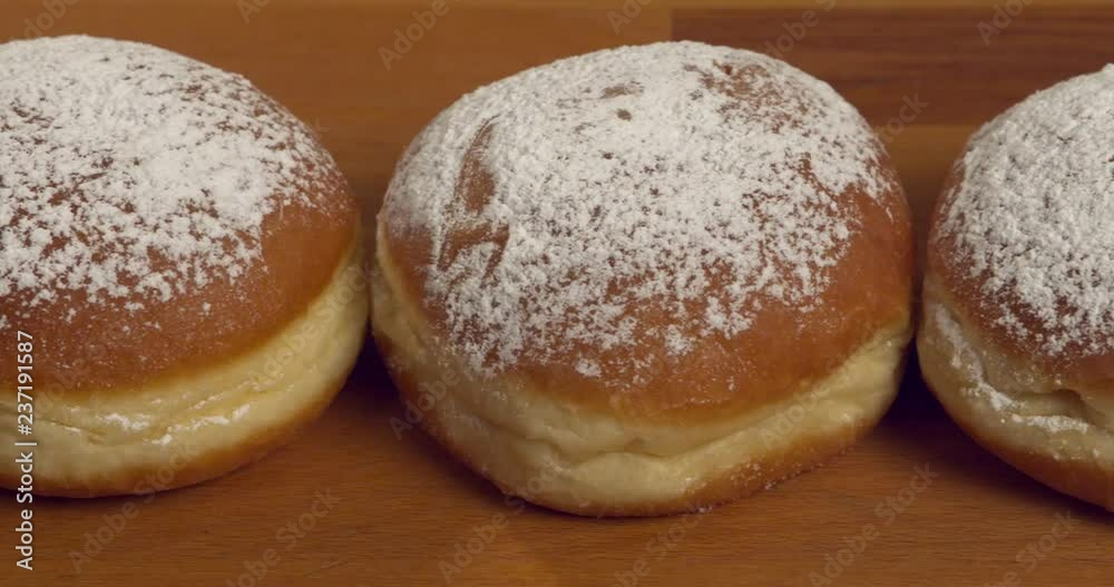 Dolly-shot over jam-filled and sugar-dusted donuts Dolly-shot over jam-filled and sugar-dusted donuts