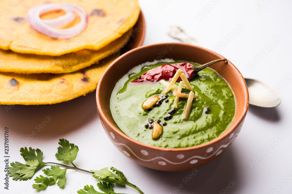 Makki di roti with sarson ka saag, popular punjabi main course recipe in winters made using corn breads mustard leaves curry. served over moody background. selective focus Makki di roti with sarson ka saag, popular punjabi main course recipe in winters made using corn breads mustard leaves curry. served over moody background. selective focus