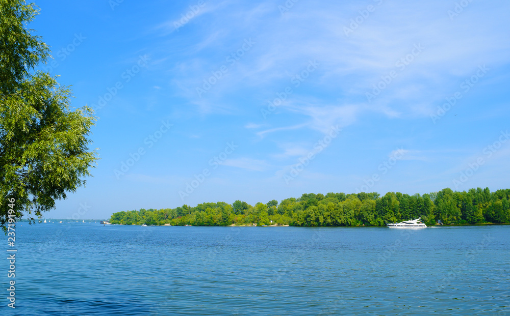 View of the river and the green island in the distance. Spring landscape. View of the river and the green island in the distance. Spring landscape.