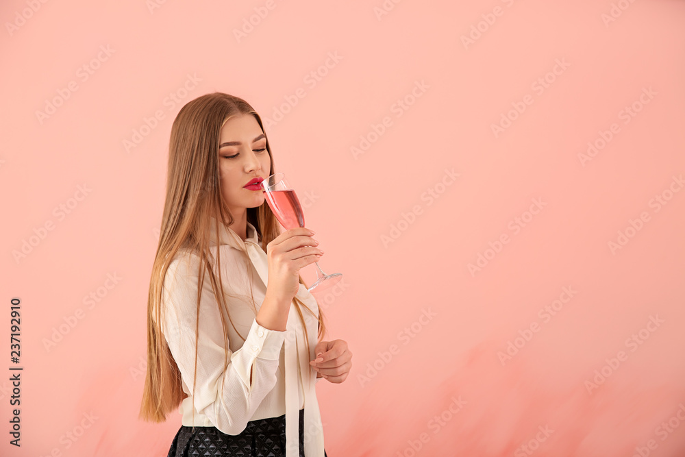 Beautiful young woman with glass of champagne on color background Beautiful young woman with glass of champagne on color background