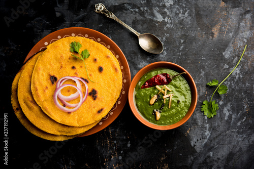 Makki di roti with sarson ka saag, popular punjabi main course recipe in winters made using corn breads mustard leaves curry. served over moody background. selective focus photo