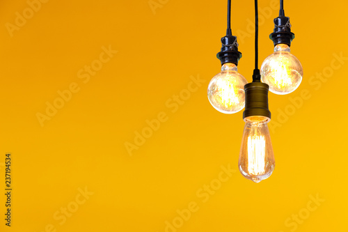 Vintage light bulb hanging over yellow  background, Idea concept.