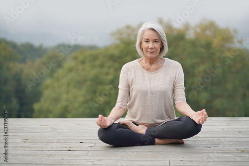  Serene senior woman meditating outdoors