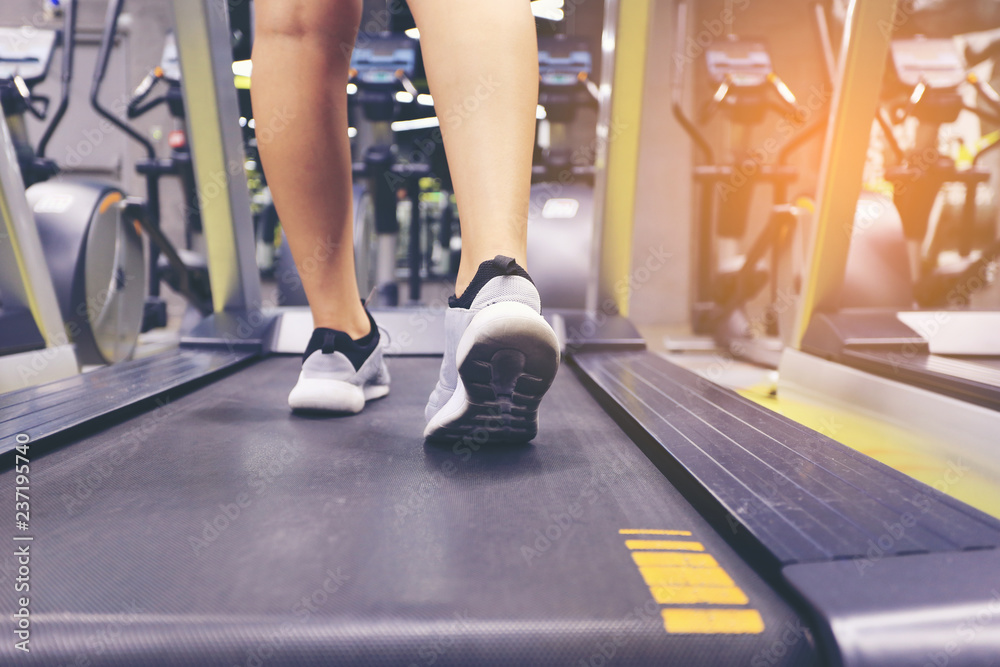 Fototapeta premium Close up on shoe, Fitness woman legs running on treadmill and burn fat in the body in the gym, Healthy lifestyle and sport concept