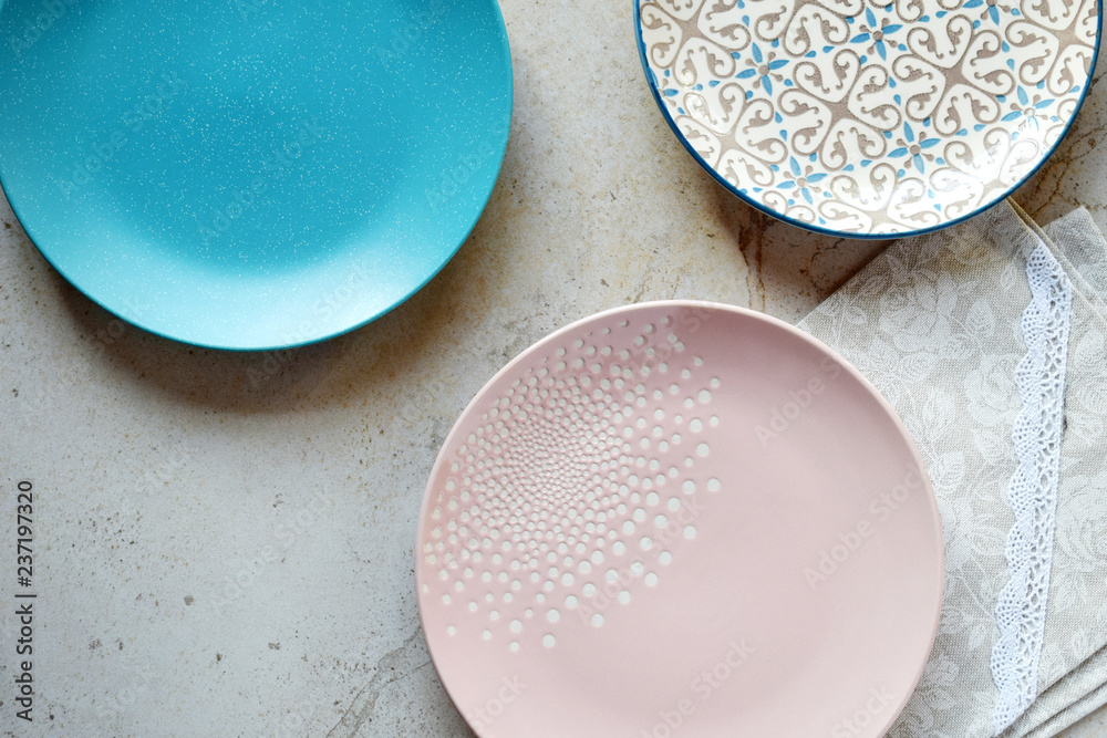 Multicolored empty ceramic plates on a marble background. Table setting. Shabby chic or retro style. Top view. Copy space. Mock up, concept for restaurant, menu Multicolored empty ceramic plates on a marble background. Table setting. Shabby chic or retro style. Top view. Copy space. Mock up, concept for restaurant, menu