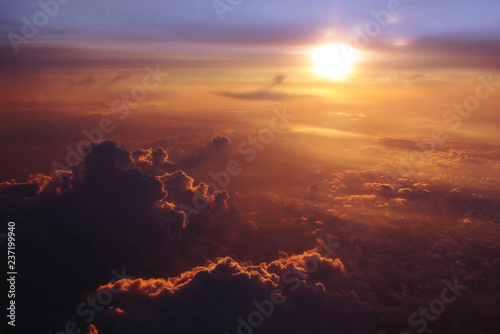 The view from the window of the plane on the clouds and the evening sun. Travel to vacation, a ticket for the evening flight. Beautiful sunset. 