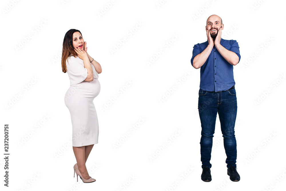 Surprised faces of a young couple on a white background. The pregnant woman and bearded man. Surprised faces of a young couple on a white background. The pregnant woman and bearded man.