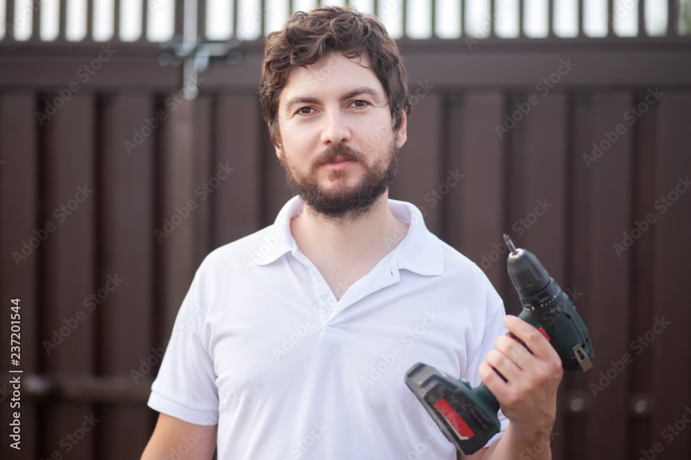 handsome bearded man holding electric drill, copyspace handsome bearded man holding electric drill, copyspace