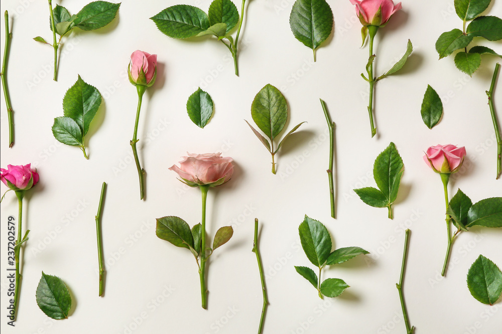 Flat lay composition with beautiful pink roses and leaves on white background Flat lay composition with beautiful pink roses and leaves on white background