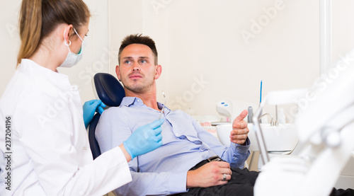 Adult man is talking with dentist