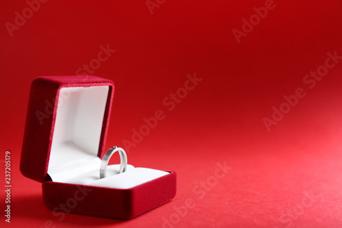 Beautiful box with engagement ring on color background