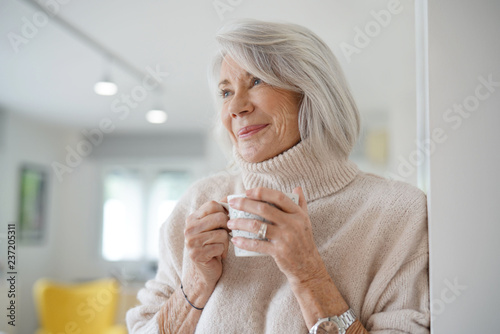  Senior woman at home with hot drink photo