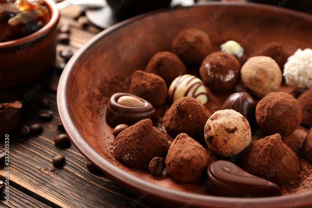 Plate with tasty chocolate truffles on table, closeup
