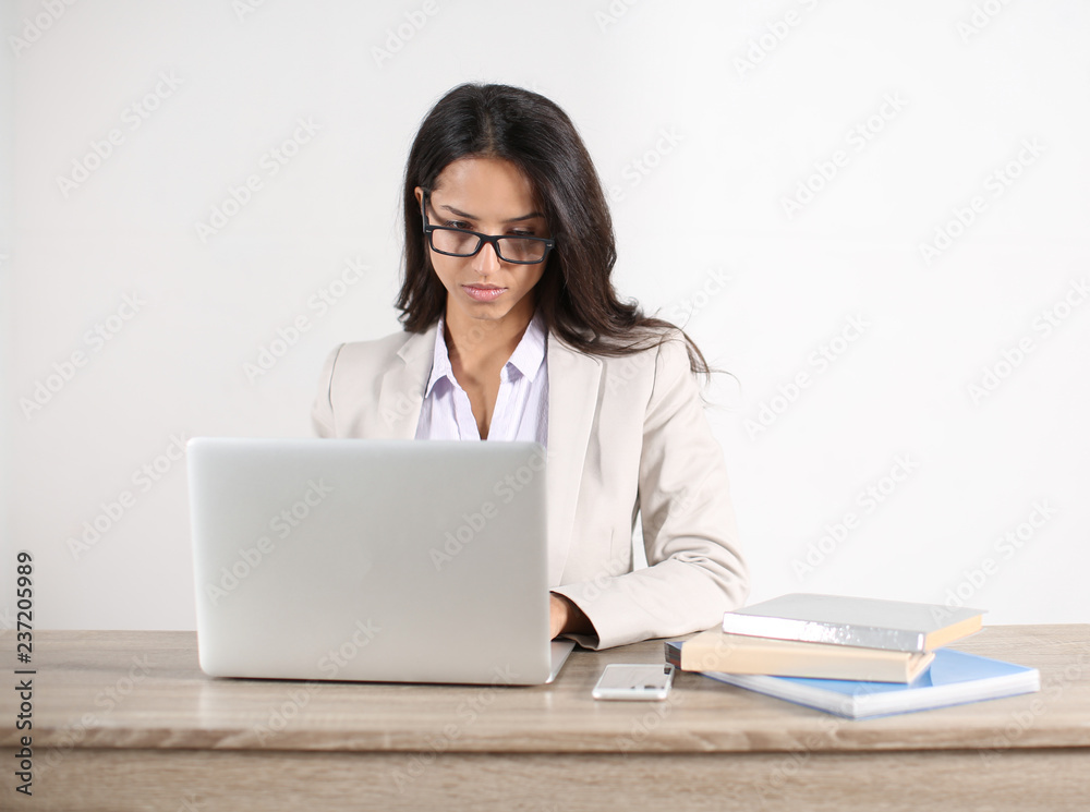 Young woman working with laptop in office Young woman working with laptop in office