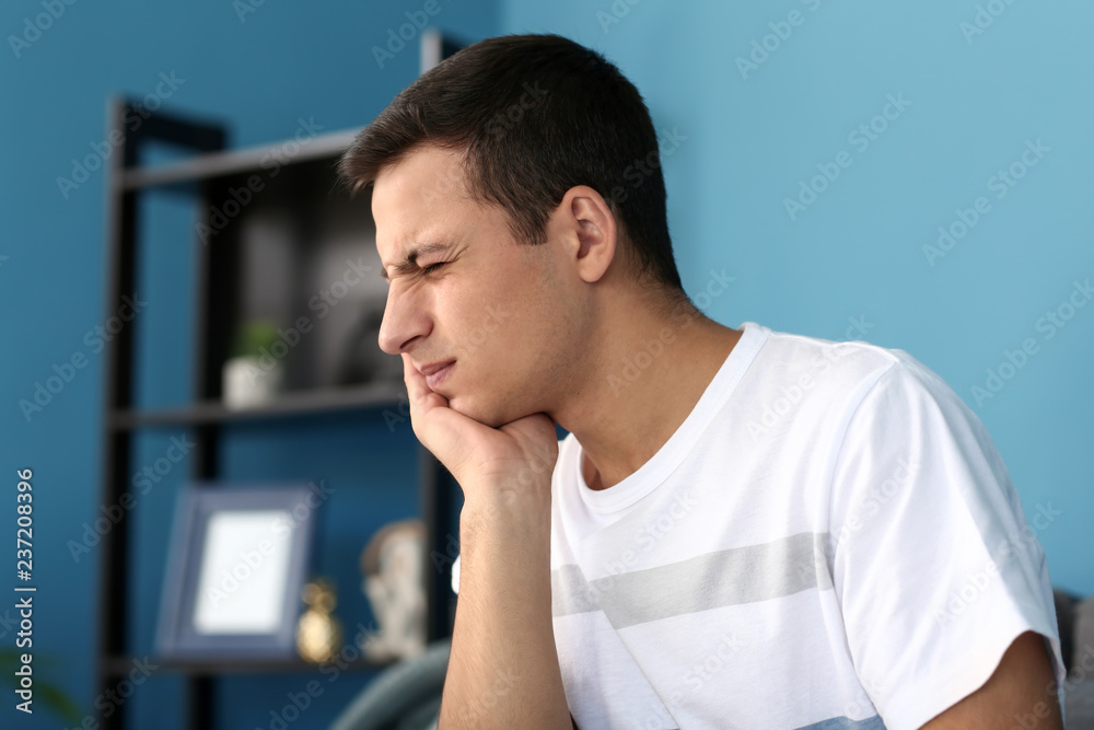 Young man suffering from toothache at home Young man suffering from toothache at home