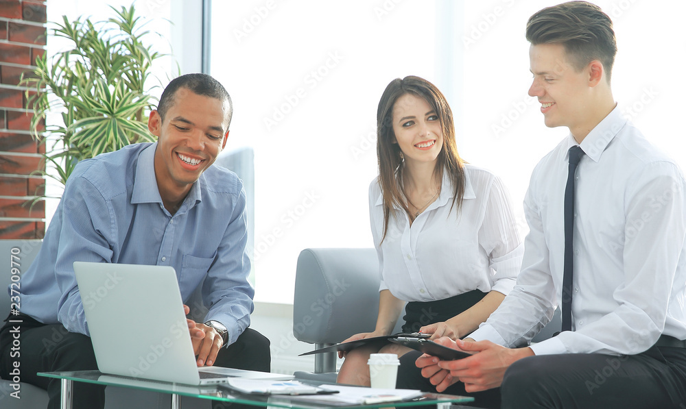 business team looking at laptop while sitting at your Desk business team looking at laptop while sitting at your Desk