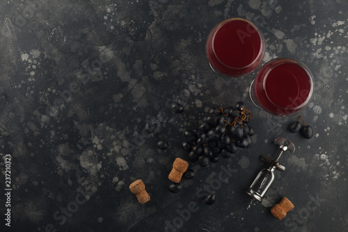 Red wine with grapes on a dark background.