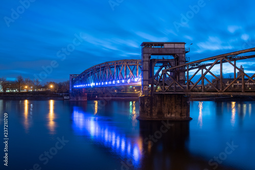 View of the illuminated old railway bridge Hubbrücke in Magdeburg, Germany.