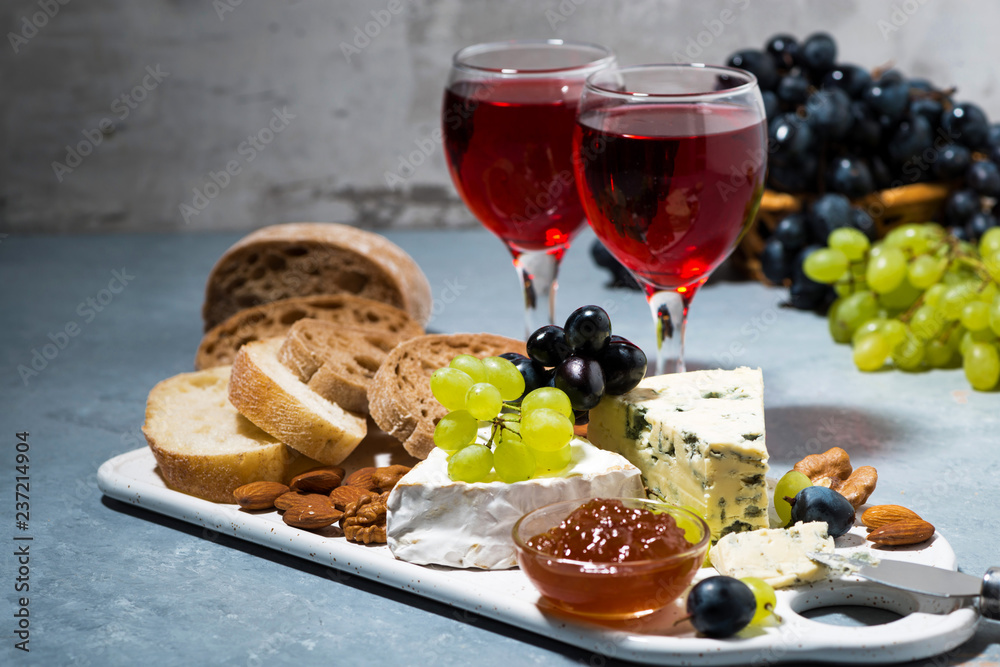 cheese plate, ciabatta, fresh grapes and two glasses of red wine