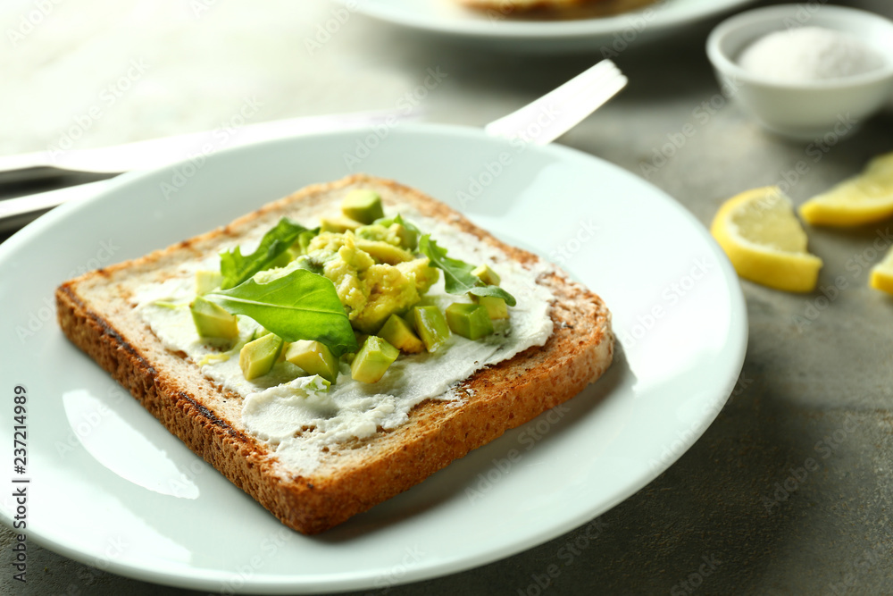 Delicious toast with avocado on plate, closeup