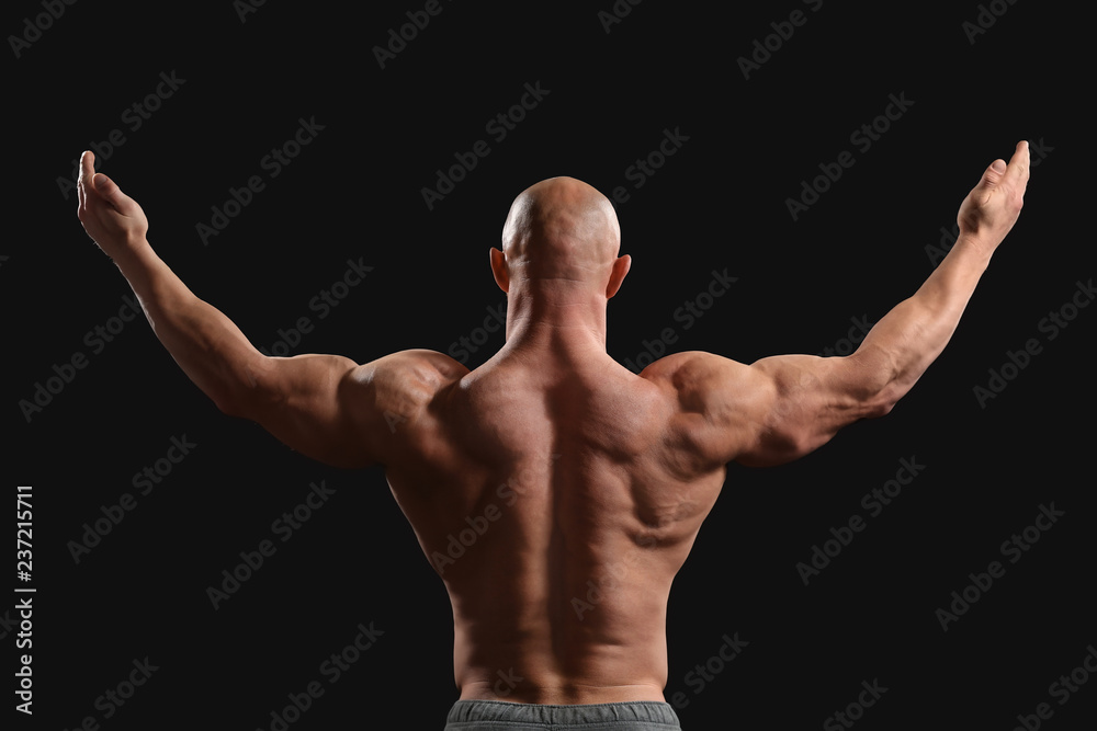 Muscular bodybuilder on dark background