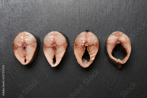 Slices of fish on grey background. Erotic concept photo
