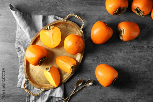 Canvas Print Tray with ripe persimmons on grey background, top view