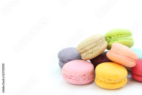 Close up many colorful fresh macarons pile isolated on white background, look delicious, have copyspace