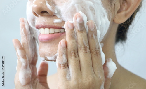 Close up Asian woman smile and washing face by make bubble facial foam and cleansing her face skin