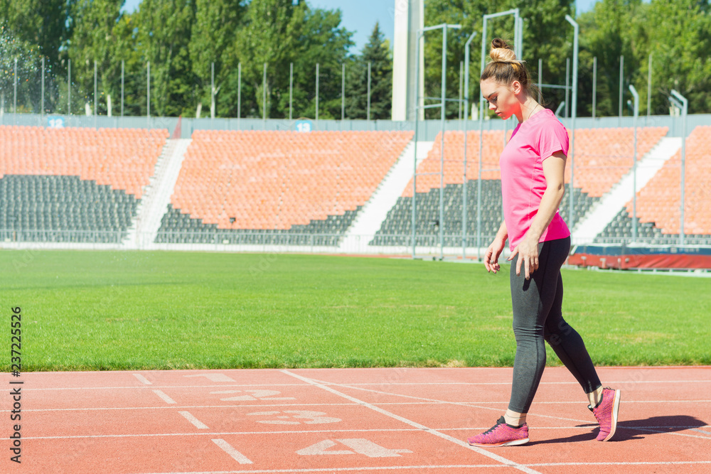 A young girl in the stadium is preparing to start.