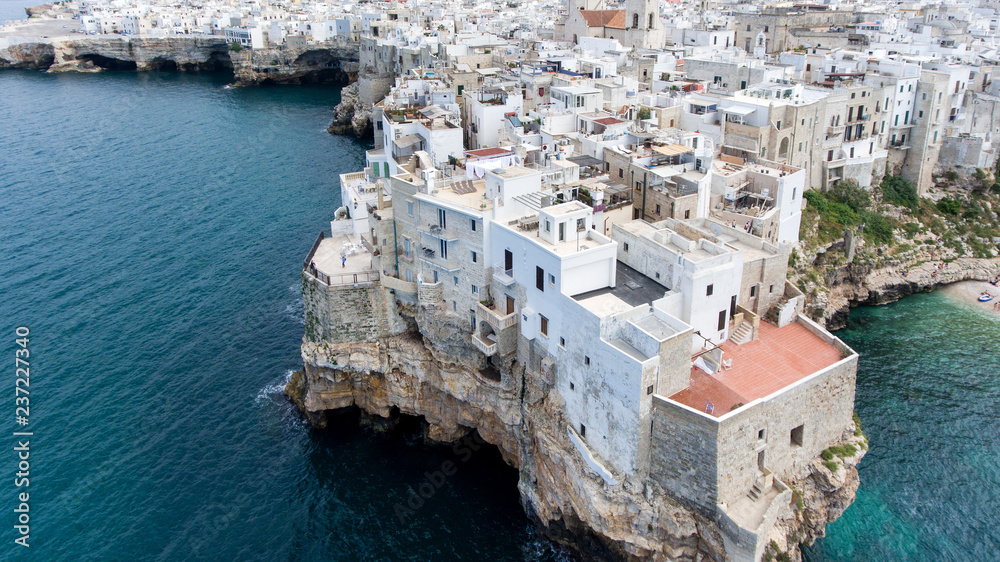 Beautiful view of old town in Polignano a Mare in Italy. Houses and buildings built on cliffs next to ocean or sea. Luxury lifestyle at the edge of the world. Concept of travelling and summer holidays