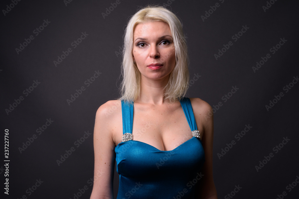 Fototapeta premium Beautiful woman with blond hair against gray background
