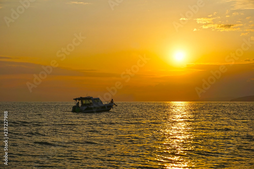 A small yacht in the sea, at a picturesque sunset © Nikolay Beletskiy