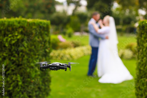 Hovering drone taking pictures of wedding couple in nature
