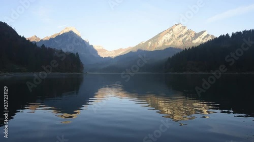 Peaceful autumn view on Obersee lake in Swiss Alps. Clear sky and mountains reflections in clear water. Nafels village, Switzerland photo
