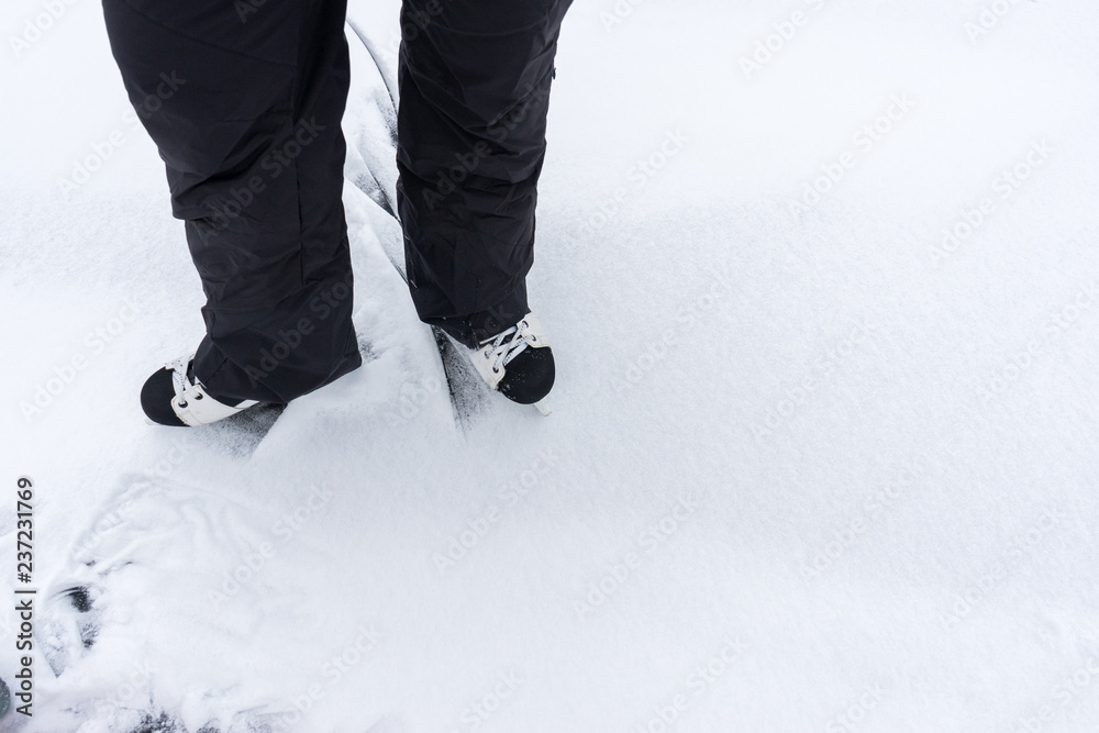 feet of man rolling on hockey skates on frozen lake