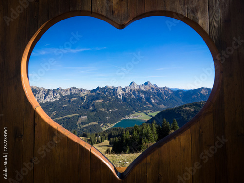 Tannheimer Tal panorama with view on the Haldensee seen through a wooden heart