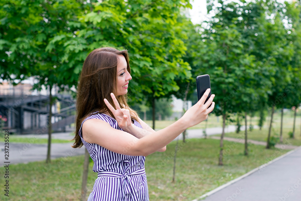 Naklejka premium Young female holding phone for picture selfie