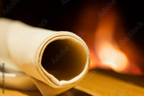 napkin resting on a plate next to a romantic fire of a fireplace