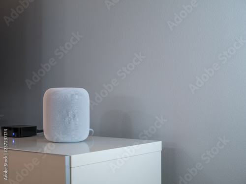 Smart wireless speaker at home to play music. Grey an white background.