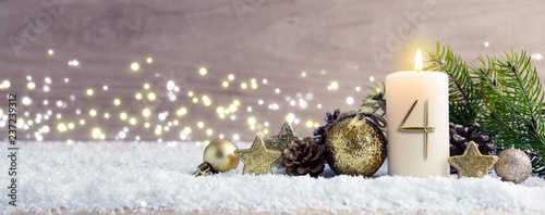 Fourth Advent.Christmas background with Advent candle and golden decoration. photo