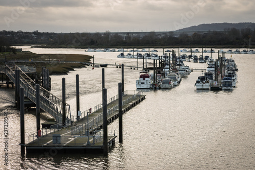 View of a jetty and pier leading to a flotilla of moored yachts on the River Medway in Rochester, England, UK photo