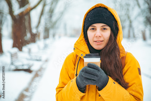 woman drinking coffee outside in park portrait. drink to go. winter time. warm up