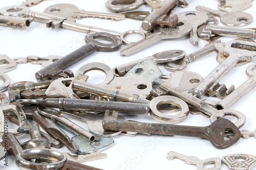 a heap of different old keys are lying in the white studio