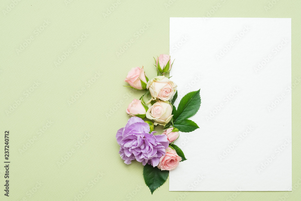 empty white paper with bunch flowers on green background. congratulation card mockup