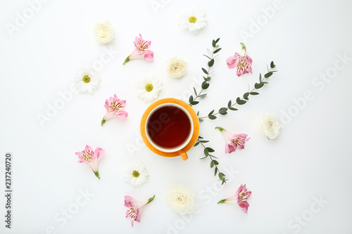 Flowers with cup of tea on white background